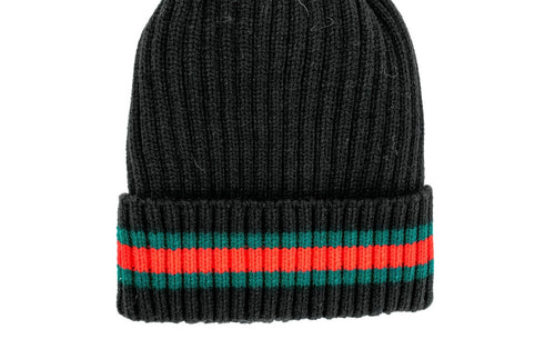 The Knit Hat with Striped Cuff is a black knitted hat featuring a folded brim adorned with two horizontal stripes, one in red and the other in green, circling the cuff. The ribbed texture adds to its cozy aesthetic.