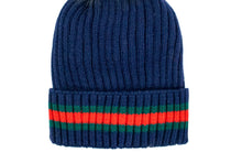 Load image into Gallery viewer, Displayed against a white backdrop is the Knit Hat with Striped Cuff, featuring a ribbed navy blue design. The folded cuff showcases horizontal red and green stripes, lending it a cozy appearance that makes it perfect for cold weather.
