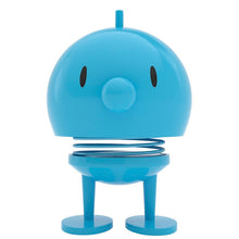 Load image into Gallery viewer, Introducing the Hoptimist Bumble, a delightful toy figure in blue featuring a round head and body, wide-set black oval eyes, and a small nose. The spring connecting its head and body adds a playful touch to your home decor. It stands upright on two flat, round feet, perfectly capturing the cheerful essence of Danish design history.
