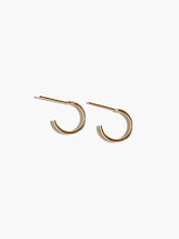 Load image into Gallery viewer, The Celine Huggie Hoops are showcased against a plain white background, highlighting their minimalist design. Made from 14k gold-filled material, these small and thin circular hoops offer a simple yet elegant look, ideal for everyday wear. They represent the brand&#39;s dedication to ethical fashion and sustainability.
