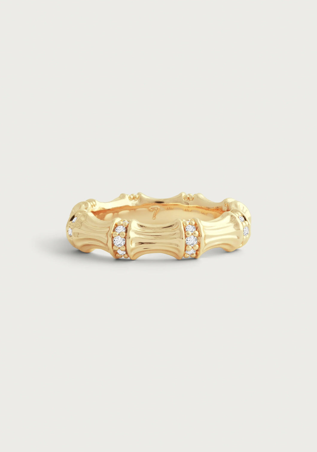 The Bamboo Single Ring, crafted in 18k gold, showcases a textured bamboo segment design. Each segment is adorned with tiny clusters of pavé crystals, beautifully highlighted against a light gray background to enhance its intricate details and elegant shine.