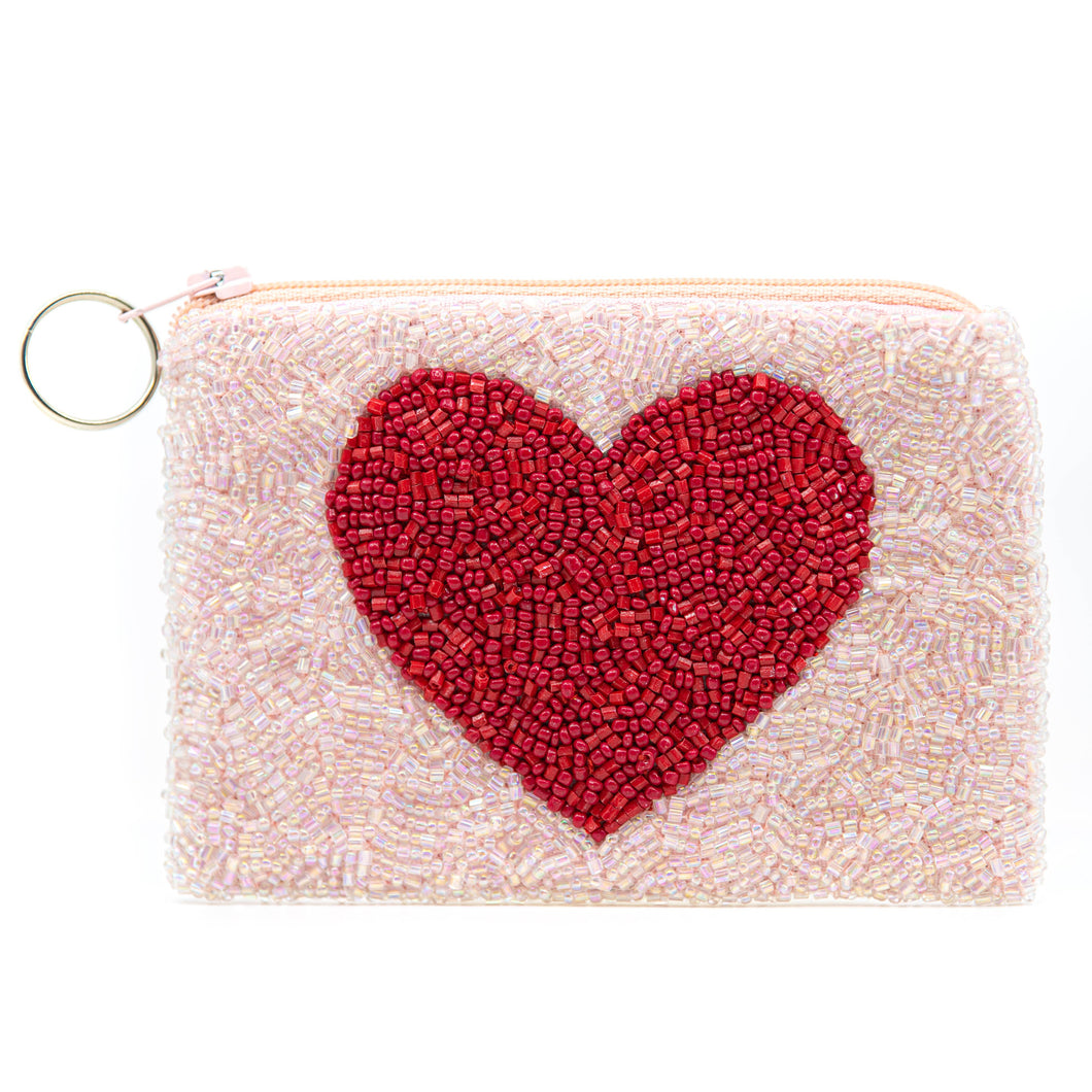 The Valentine’s Beaded Coin Purse is a small pouch showcasing timeless elegance with an intricate crafted design featuring a large red heart made of beads, surrounded by light pink beads. It has a zipper closure and metal ring, making it both versatile and artistic.