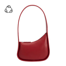 Load image into Gallery viewer, The Willow Recycled Vegan Shoulder Bag is a sleek red accessory designed with recycled vegan leather. It boasts a unique curved shape, smooth texture, single shoulder strap, and top zipper closure. A black recycling symbol on the plain white backdrop complements its modern minimalist style.
