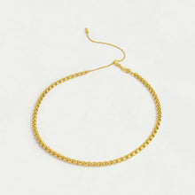 Load image into Gallery viewer, The Tokyo Chain Necklace, a gold-plated choker with a signature box chain design and small interlocking links, ends in an adjustable bar. It rests in a circular shape on a plain light background, highlighting its elegant simplicity.
