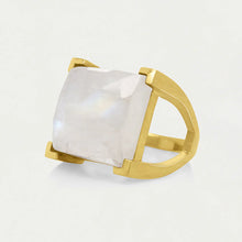 Load image into Gallery viewer, The Plaza Ring features a minimalist gold design with a large, square-cut moonstone. The band splits into dual prongs on each side to securely hold the hand-faceted gemstone, which has a milky-white sheen against a light backdrop.
