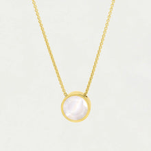 Load image into Gallery viewer, The Signature Pendant features a gold chain necklace with a round, iridescent mother-of-pearl pendant set in a gold bezel, hanging centrally against a plain white background.
