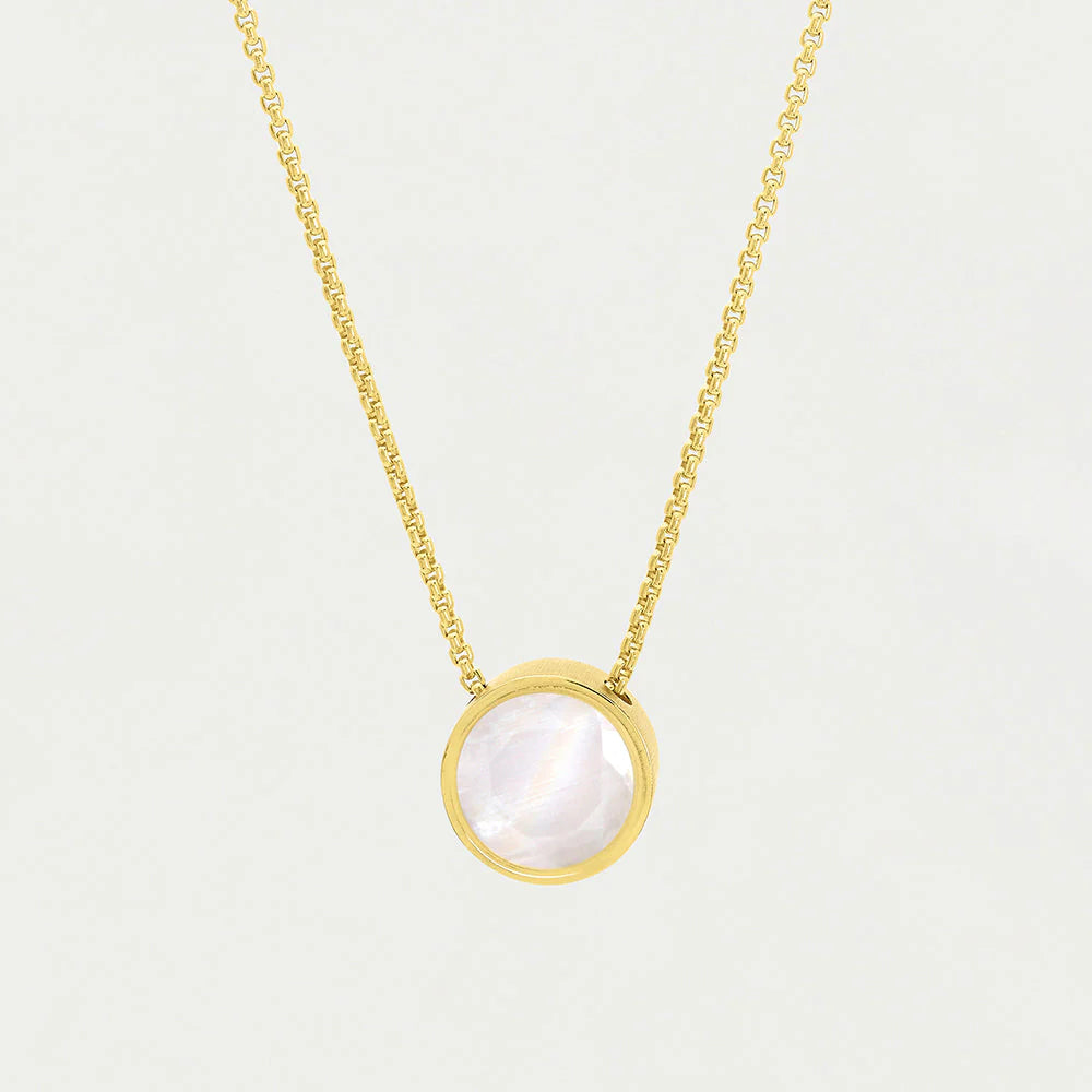 The Signature Pendant features a gold chain necklace with a round, iridescent mother-of-pearl pendant set in a gold bezel, hanging centrally against a plain white background.