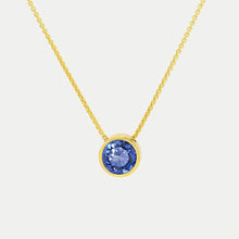 Load image into Gallery viewer, Introducing the Signature Pendant: a gold necklace with a circular blue gemstone in a simple gold bezel. The fine link chain adds to its elegance, beautifully showcased against a plain, light background.
