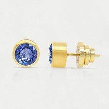 Load image into Gallery viewer, Two gold Signature Midi Studs showcase circular man-made blue gemstones. One earring is presented from the front, highlighting the sparkling stone, while the other reveals Dean Davidson&#39;s elegant gold setting and post with a butterfly clutch against a plain white background.
