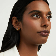 Load image into Gallery viewer, A person with long, dark hair looks to the side, wearing a white top. Their dark eyes are enhanced by Dean Davidson’s Signature Midi Studs with blue man-made gemstones and a gold outer ring. The plain off-white background accentuates the subject&#39;s serene expression.
