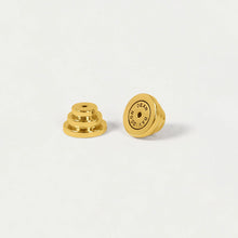 Load image into Gallery viewer, Two small, round, gold-tone earring backs rest on a white background. The left piece is side-viewed to show its layered structure, while the right stands upright with &quot;DAVIDSON&quot; engraved. These backs elegantly complement Signature Midi Studs.
