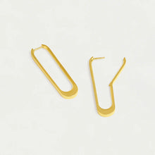 Load image into Gallery viewer, The Crosby Drop Hoops are 18kt gold earrings shaped like elongated paperclips with a curved bottom and open clasp design, inspired by New York architecture, offering a sleek and minimalistic look against a white background.
