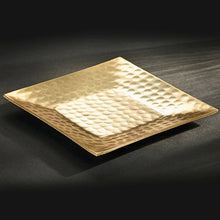 Load image into Gallery viewer, A Gold Hammered Tray - 6” rests on a dark surface, its gold finish gleaming under the soft light. The hammered texture accentuates circular indentations, and the reflective quality highlights its elegance against the subtly lit background.
