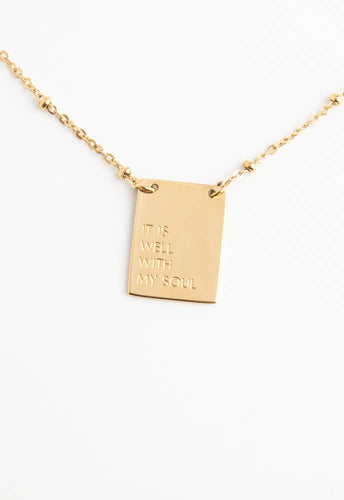 The 14K gold-plated It Is Well Necklace features a rectangular pendant with 