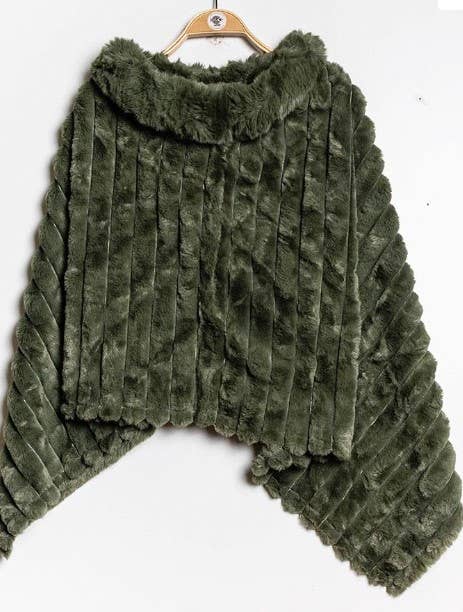 Displayed on a light wooden hanger against a plain white background is the Faux Fur Poncho, a fuzzy, dark green garment featuring a ribbed textured pattern. This stylish piece boasts a soft, high collar and an elegantly draped asymmetrical hem that radiates cozy warmth.