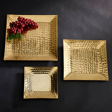 Load image into Gallery viewer, Three Gold Hammered Trays, each with a 6&quot; diameter and featuring a rich hammered texture, are placed against a dark background. The largest of these elegant trays holds a cluster of red grapes. The trays&#39; metallic sheen and sophisticated design create a luxurious and elegant display.
