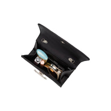 Load image into Gallery viewer, An open black Sadie Satin Top Handle Bag with a clasp closure displays a blue compact, rhinestone-adorned lipstick, sunglasses, and a compact mirror, all neatly arranged and visible from above against a plain white background.
