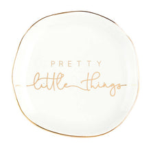 Load image into Gallery viewer, The Trinket Tray - Little Things is a charming, small white ceramic dish with a slightly irregular round shape. It features &quot;Pretty little things&quot; in elegant light brown script and is accented with a metallic gold rim for added elegance.
