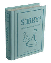 Load image into Gallery viewer, The image displays the Sorry! Vintage Bookshelf Edition, a collectible version of the board game crafted to look like a fabric-wrapped book. It boasts a light green cover with &quot;SORRY! VINTAGE BOOKSHELF EDITION&quot; printed on it and illustrations of two game pieces. The spine is marked with &quot;SORRY!&quot; and includes details about suitable ages and number of players.
