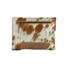 Load image into Gallery viewer, The Diana Clutch - Cowhide Hairon Leather boasts a brown and white spotted cowhide hairon leather design. It includes a brown leather zipper pocket with a matching accent at the bottom, while the fur texture and whipstitch detailing contribute to its rustic and natural charm.
