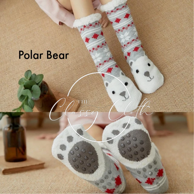 The Non-Slip Sherpa Lined Socks - Polar Bear are cozy, knee-high socks perfect for delightful, cozy days. They feature a red snowflake pattern on a gray background at the top and display a bear face on the foot. Non-slip paw prints adorn the bottom alongside "Polar Bear" text.