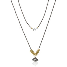 Load image into Gallery viewer, The Eden’s Pyrite Apple Necklace features a beautiful handcrafted design with two layers. The lower layer showcases a series of small gold-filled rings arranged in a V shape, complemented by a dangling teardrop-shaped metallic pendant. Slender, dark chains and a silver lobster clasp enhance the elegance of this stunning accessory.
