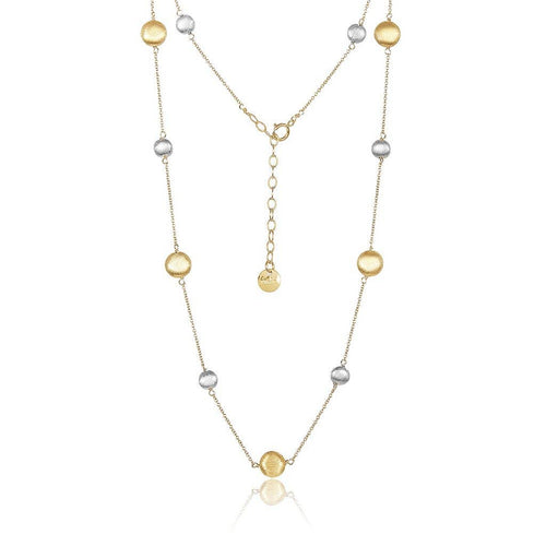 The Eclipse Necklace is a sophisticated gold-plated piece showcasing an arrangement of alternating gold and sterling silver round beads on a delicate chain. It includes an adjustable clasp with an extender chain, finished with a small gold bead, enabling customizable length. The necklace is beautifully displayed in a V-shape against a white background.